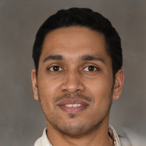 Joyful latino young-adult male with short  black hair and brown eyes