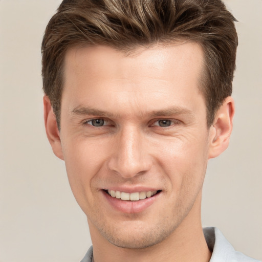 Joyful white young-adult male with short  brown hair and grey eyes