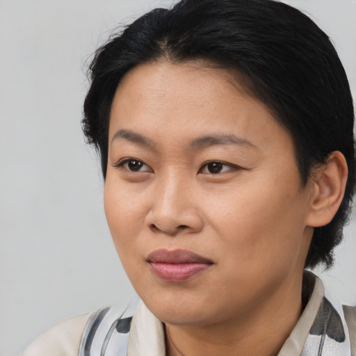 Joyful asian adult female with medium  black hair and brown eyes