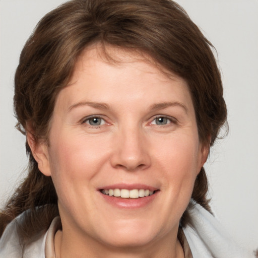 Joyful white adult female with medium  brown hair and grey eyes