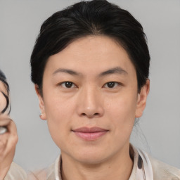 Joyful asian young-adult female with medium  brown hair and brown eyes