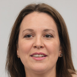 Joyful white adult female with long  brown hair and grey eyes