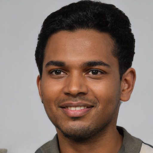 Joyful black young-adult male with short  black hair and brown eyes