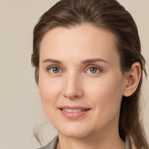 Joyful white young-adult female with medium  brown hair and grey eyes