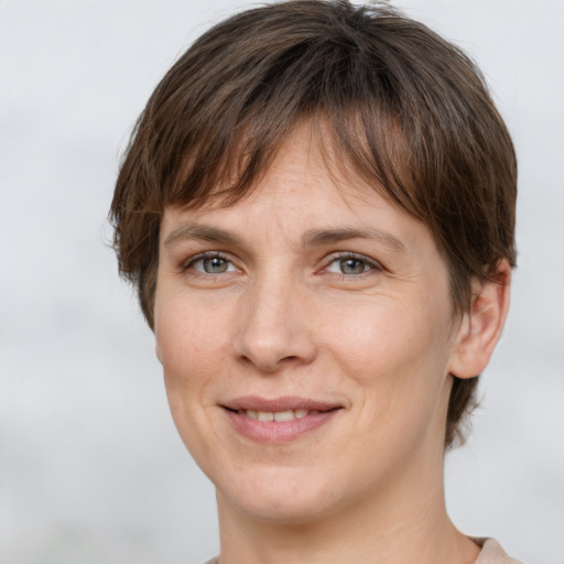 Joyful white young-adult female with short  brown hair and grey eyes