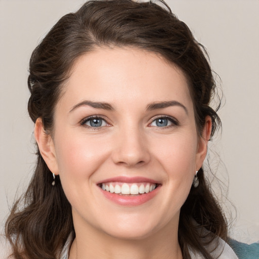 Joyful white young-adult female with medium  brown hair and grey eyes