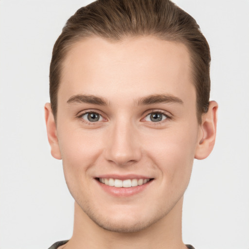 Joyful white young-adult male with short  brown hair and grey eyes