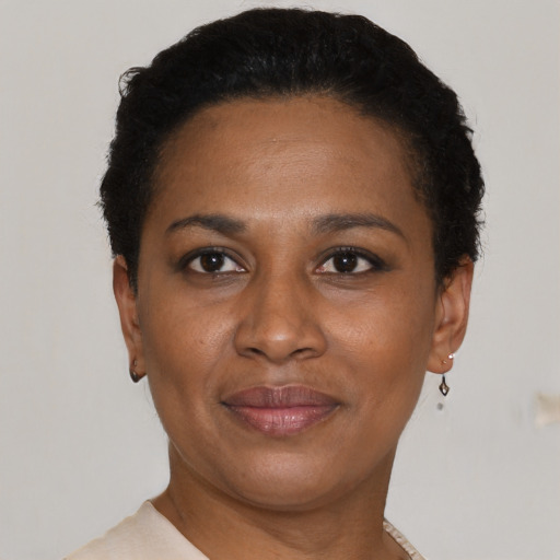 Joyful black young-adult female with short  black hair and brown eyes