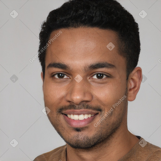 Joyful black young-adult male with short  brown hair and brown eyes