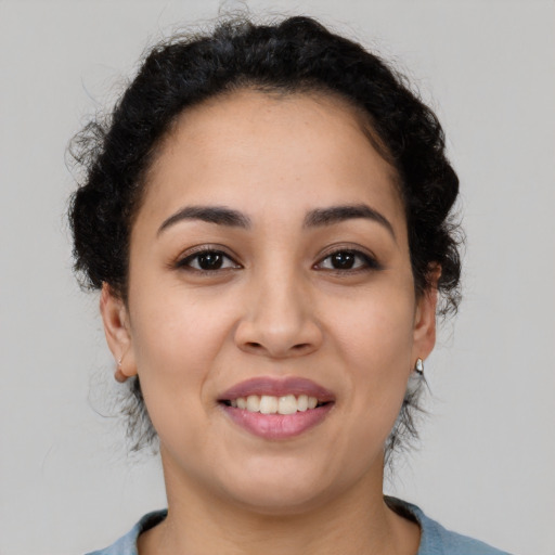 Joyful latino young-adult female with medium  brown hair and brown eyes