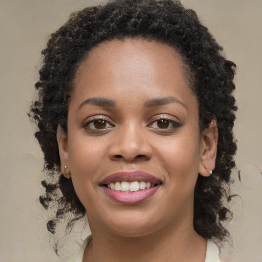 Joyful black young-adult female with long  brown hair and brown eyes