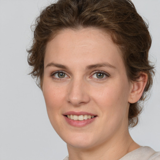 Joyful white young-adult female with medium  brown hair and green eyes