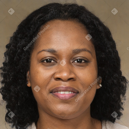 Joyful black adult female with long  brown hair and brown eyes