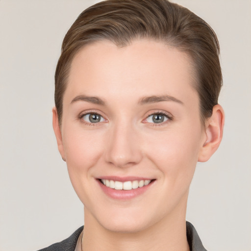 Joyful white young-adult female with short  brown hair and grey eyes