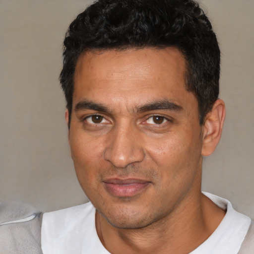 Joyful white young-adult male with short  black hair and brown eyes