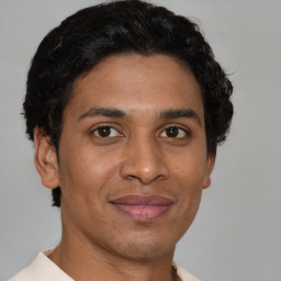 Joyful latino young-adult male with short  brown hair and brown eyes