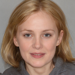 Joyful white young-adult female with medium  brown hair and blue eyes