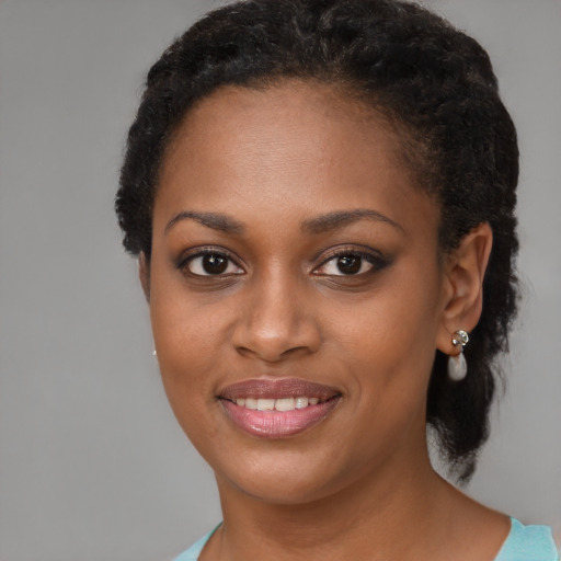 Joyful black young-adult female with short  black hair and brown eyes