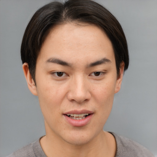 Joyful asian young-adult male with short  brown hair and brown eyes