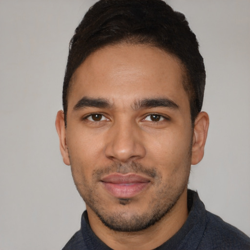 Joyful latino young-adult male with short  black hair and brown eyes