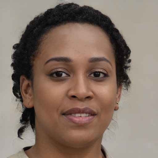 Joyful black young-adult female with medium  brown hair and brown eyes