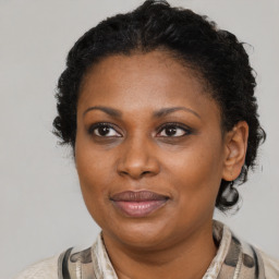 Joyful black adult female with medium  brown hair and brown eyes