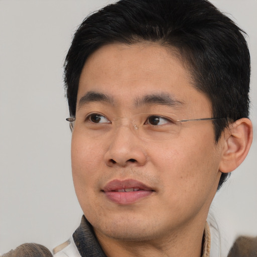 Joyful asian young-adult male with short  brown hair and brown eyes