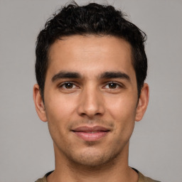 Joyful white young-adult male with short  black hair and brown eyes