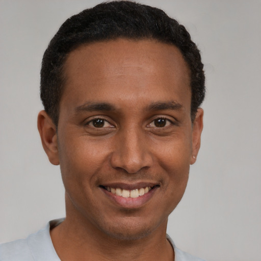Joyful latino young-adult male with short  black hair and brown eyes