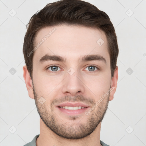 Joyful white young-adult male with short  brown hair and grey eyes