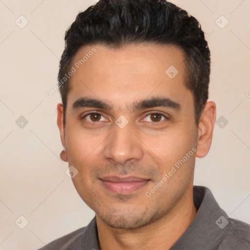 Joyful latino young-adult male with short  black hair and brown eyes