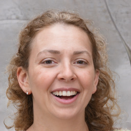 Joyful white adult female with medium  brown hair and grey eyes