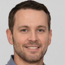 Joyful white adult male with short  brown hair and grey eyes