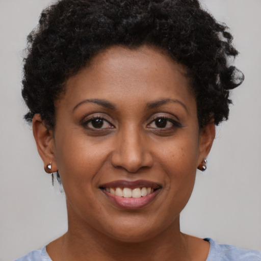Joyful black young-adult female with short  brown hair and brown eyes