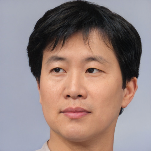 Joyful asian adult male with short  black hair and brown eyes