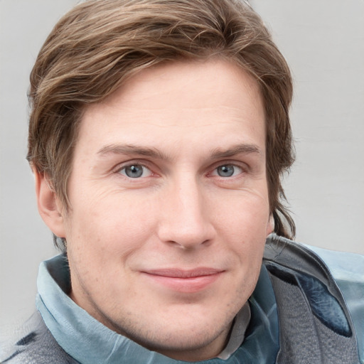 Joyful white young-adult male with short  brown hair and blue eyes