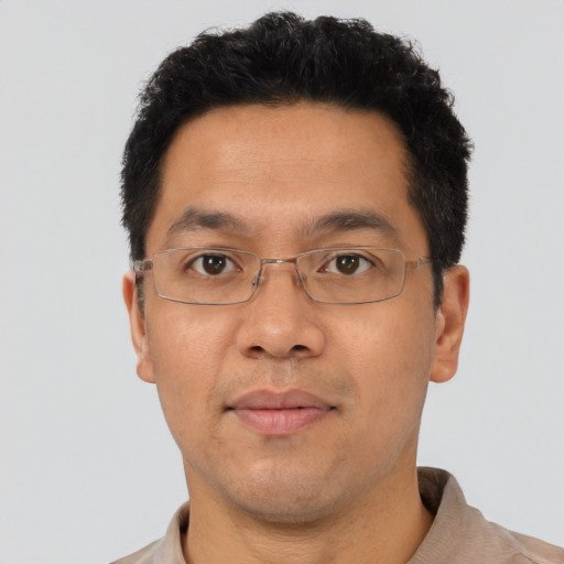 Joyful asian adult male with short  brown hair and brown eyes