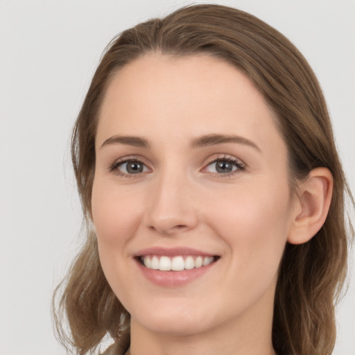 Joyful white young-adult female with long  brown hair and grey eyes