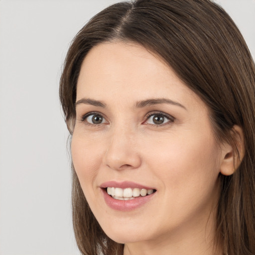 Joyful white young-adult female with long  brown hair and brown eyes