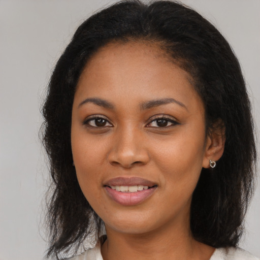 Joyful black young-adult female with long  brown hair and brown eyes
