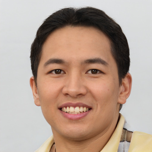 Joyful asian young-adult male with short  brown hair and brown eyes