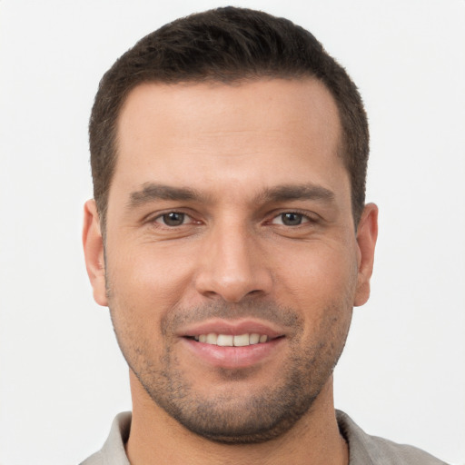 Joyful white young-adult male with short  brown hair and brown eyes