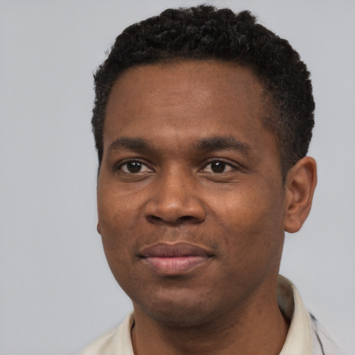 Joyful black young-adult male with short  black hair and brown eyes