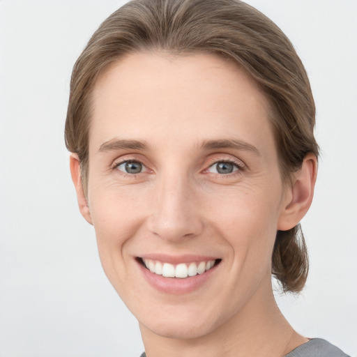 Joyful white young-adult female with short  brown hair and grey eyes