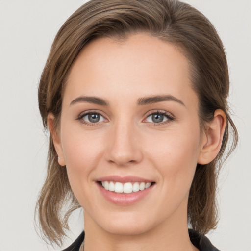 Joyful white young-adult female with medium  brown hair and green eyes