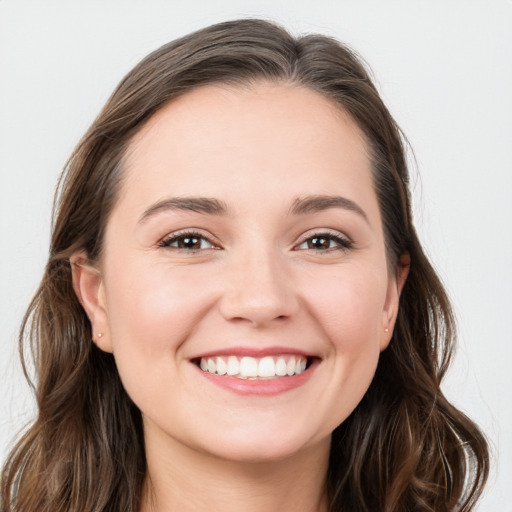 Joyful white young-adult female with long  brown hair and blue eyes