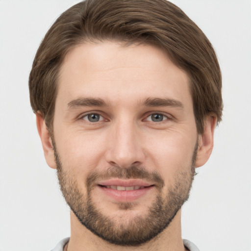 Joyful white young-adult male with short  brown hair and grey eyes