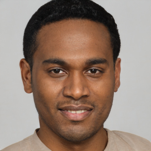 Joyful black young-adult male with short  black hair and brown eyes