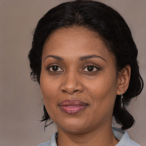 Joyful black adult female with medium  brown hair and brown eyes