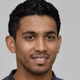 Joyful latino young-adult male with short  brown hair and brown eyes